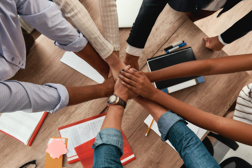 multicultural,team.,top,view,of,business,people,holding,hands,together